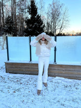 A lady wears a white goose-down garment.